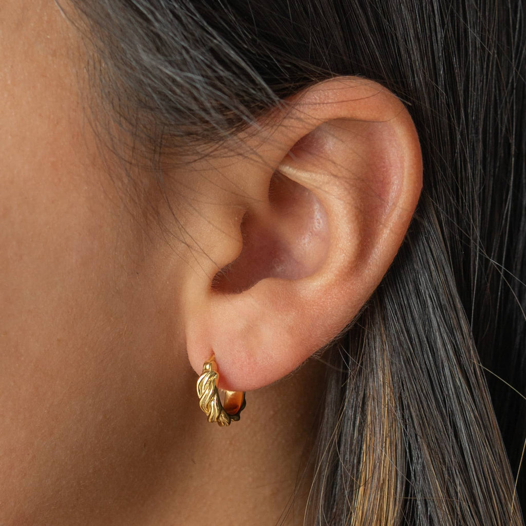 Stylish twisted gold hoop earrings, perfect for both everyday wear and special occasions.